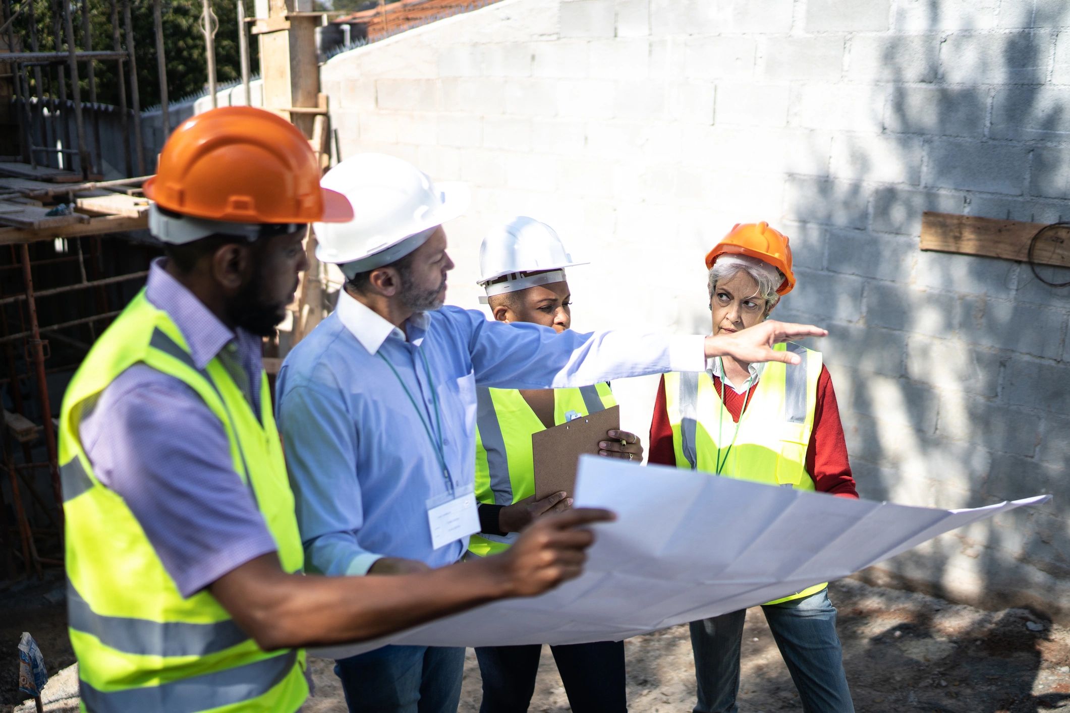 Construction workers discussing plans during a safety meeting